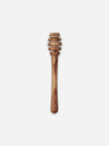 A wooden honey dipper with a natural olive wood grain pattern, shown vertically against a plain light gray background.