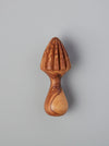 A small wooden citrus juicer with a ribbed cone top and curved handle, shown against a plain light gray background.