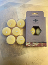 Beeswax tea light candles with a brown cardboard package with a logo of a bee on a gold surface