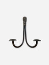 A dark metal two-hook wall hook with a rustic, weathered finish, shown against a plain light gray background.