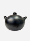 A black ceramic lidded pot with two side handles, photographed against a plain light gray background.