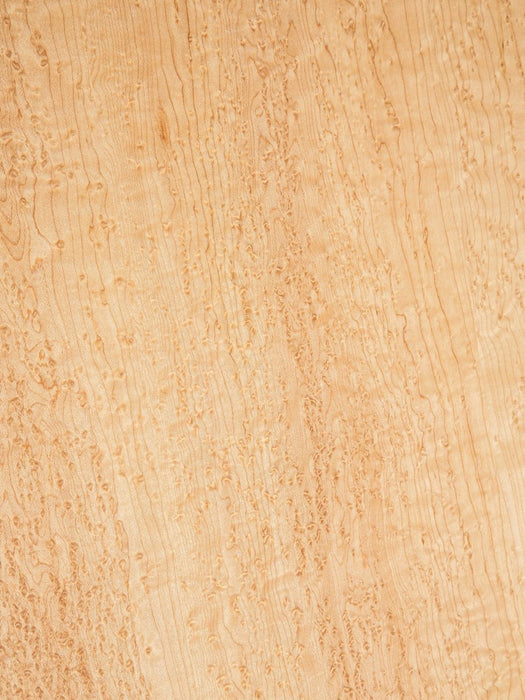 A close-up texture of light tan wood grain with natural wavy patterns and subtle darker brown lines.