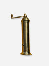 A vintage brass wall-mounted water pump or hydrant with a cylindrical body, engraved markings, and a curved hand crank extending to the left, shown against a plain light gray background.