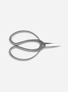 A pair of silver metal hair shears with a polished finish, shown from a top-down perspective on a light gray background.