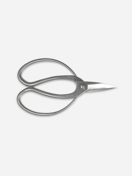 A pair of silver metal hair shears with a polished finish, shown from a top-down perspective on a light gray background.