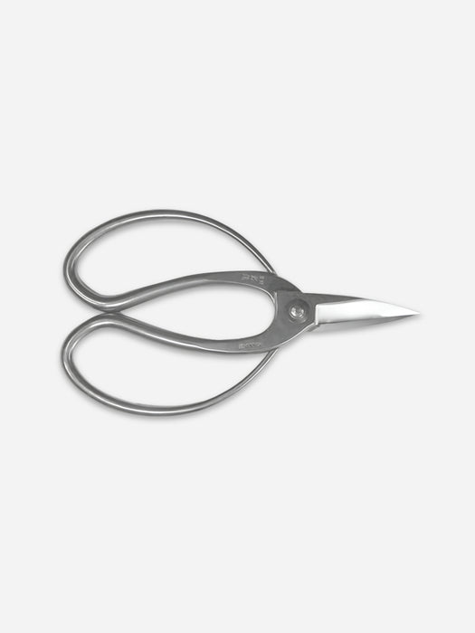 A pair of silver metal hair shears with a polished finish, shown from a top-down perspective on a light gray background.
