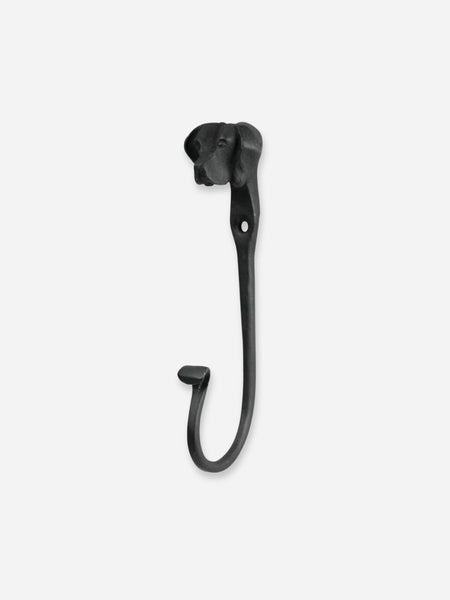 A black metal wall hook shaped like a stylized dog head, shown against a plain light gray background.
