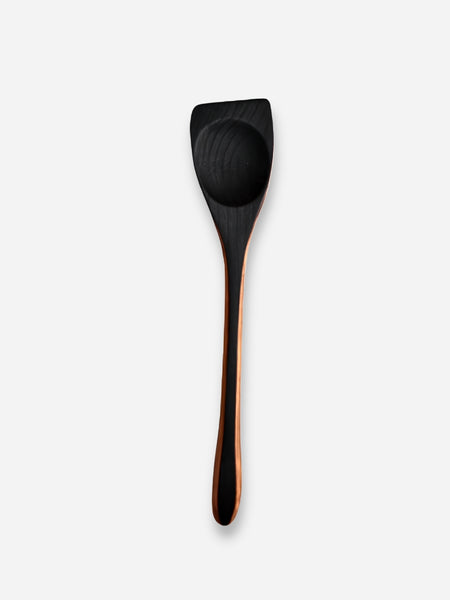 A single wooden spoon with a dark, almost black, rounded bowl and a warm brown handle, shown vertically against a light gray background.