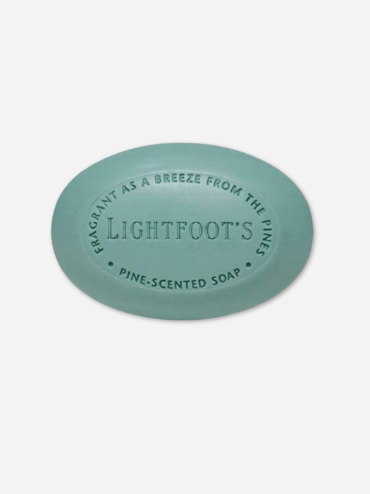 A round, light blue-green bar of soap with embossed text reading 'LIGHTFOOT'S PINE-SCENTED SOAP' on a clean, light gray background.