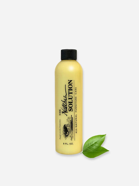 A bottle of The Natchez Solution All-Natural Furniture Care cleaner, shown against a white surface