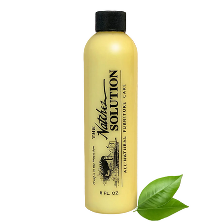 A bottle of The Natchez Solution All-Natural Furniture Care cleaner, shown against a white surface