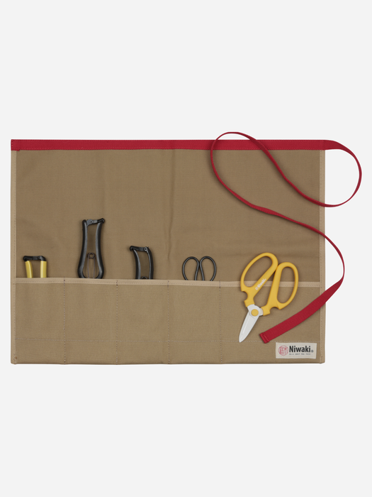 A beige canvas tool roll-up pouch with a red trim and red strap, holding various hand tools including yellow-handled scissors, on a light gray background.