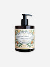 A bottle of Orange Blossom Marseille Soap by Luxe & Floral, featuring a black pump dispenser on an amber glass bottle with a vintage-style cream label decorated with orange blossoms.