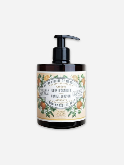 A bottle of Orange Blossom Marseille Soap by Luxe & Floral, featuring a black pump dispenser on an amber glass bottle with a vintage-style cream label decorated with orange blossoms.