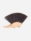 A hedgehog-shaped wooden hair bristle brush with dark brown to black bristles and a light natural wood body, shown on a plain light gray background.