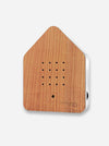 A house-shaped wooden intercom receiver with a warm brown wood grain finish and a white side panel, shown on a light gray background.