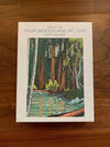 The front cover of the 'Muir Woods and Mt. Tam' note card box by Tom Killion, featuring a forest illustration, placed on a wooden surface.