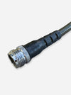 A close-up of a black industrial cable connector with a metallic silver threaded male end and a braided metal cable, shown on a light gray background.