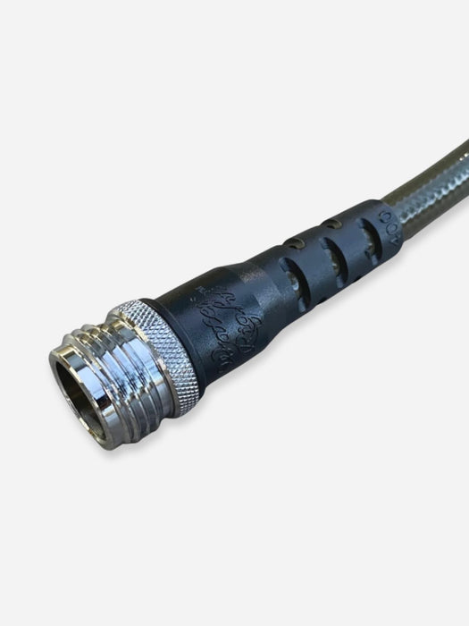 A close-up of a black industrial cable connector with a metallic silver threaded male end and a braided metal cable, shown on a light gray background.