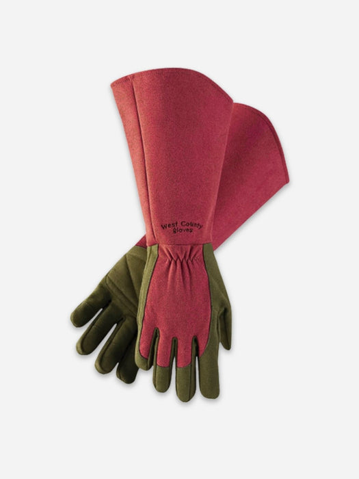 A pair of long protective work gloves with a dusty rose pink leather body and olive green palms and fingers, displayed on a light gray background.