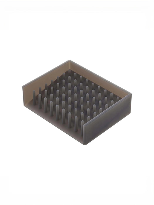 A rectangular gray silicone or rubber soap tray with dense upright bristles, shown on a plain white background.