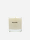 A Maison Louis Marie scented candle in a clear glass jar with cream-colored wax, centered on a light gray background.