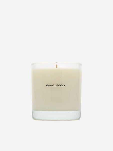 A Maison Louis Marie scented candle in a clear glass jar with cream-colored wax, centered on a light gray background.